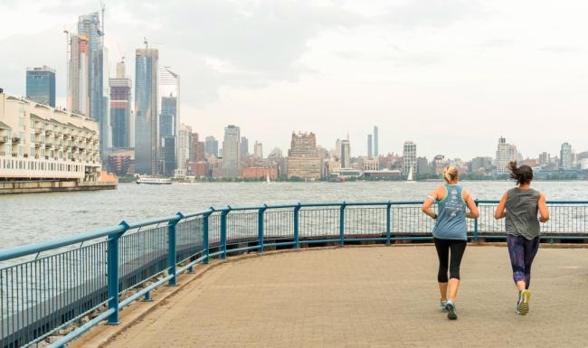 two people jogging on a bridge